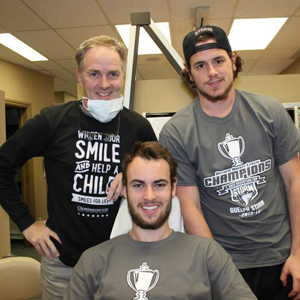 A man wearing a shirt that says smile and help a child