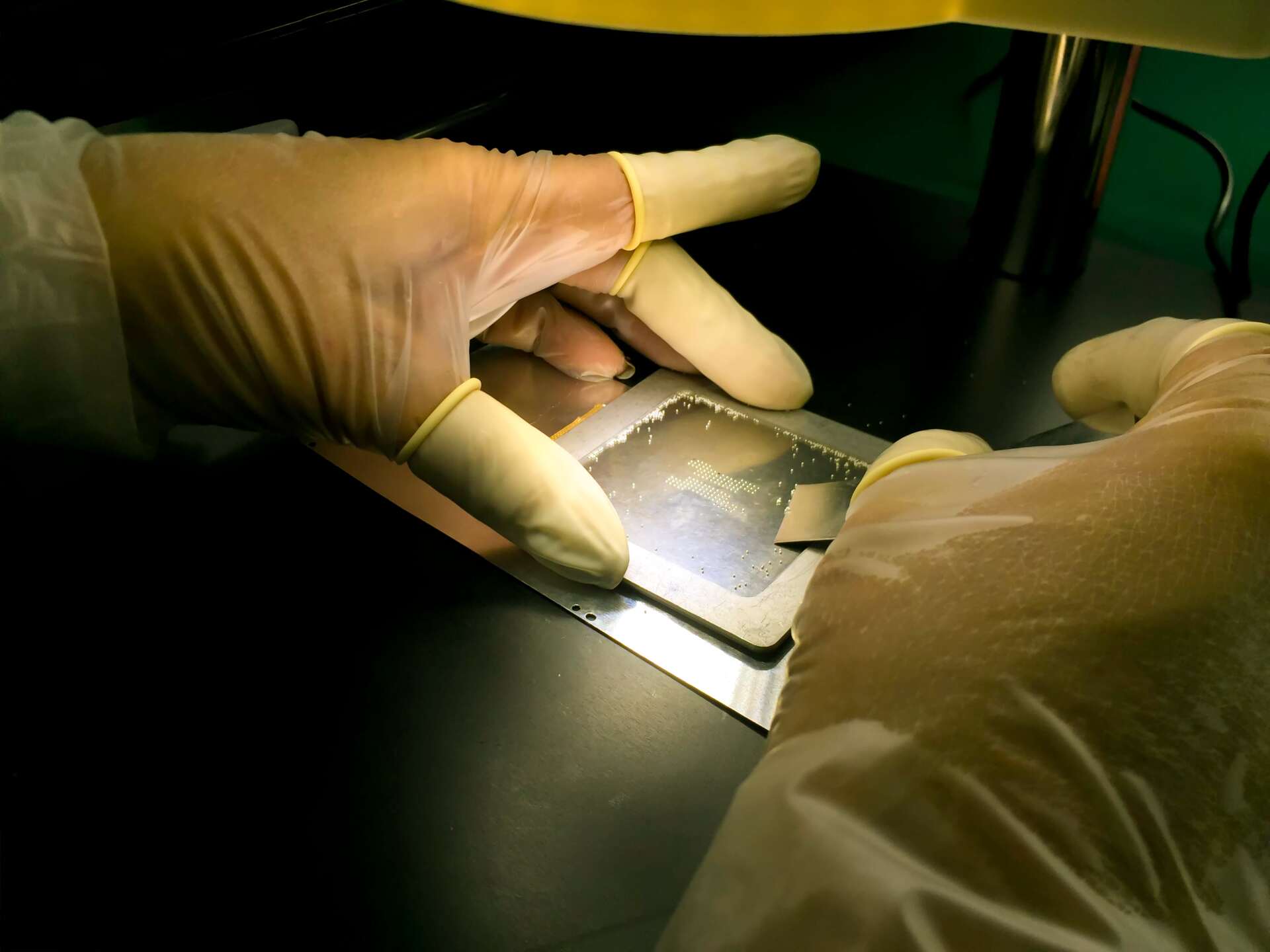 Hands of engineer used BGA reballing stencil template for rework BGA