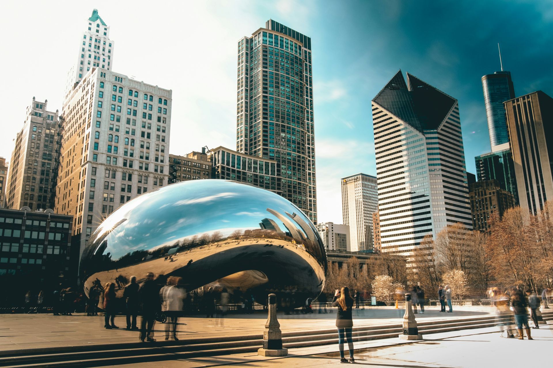 Cloud Gate sculpture in Chicago’s Millennium Park with downtown skyscrapers and people nearby
