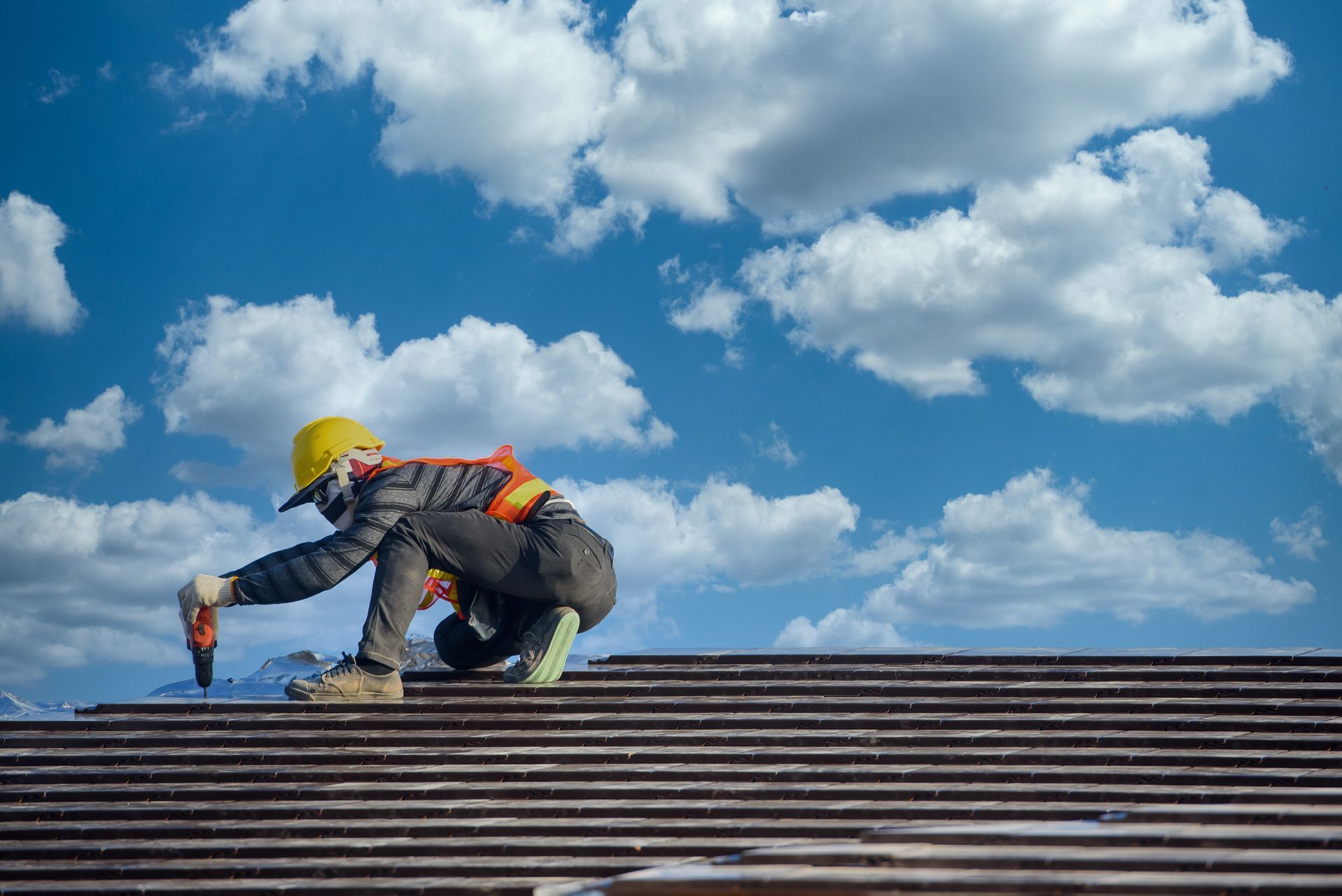 Roof installers are installing the roof of the house that is ceramic tile roof at construction site.