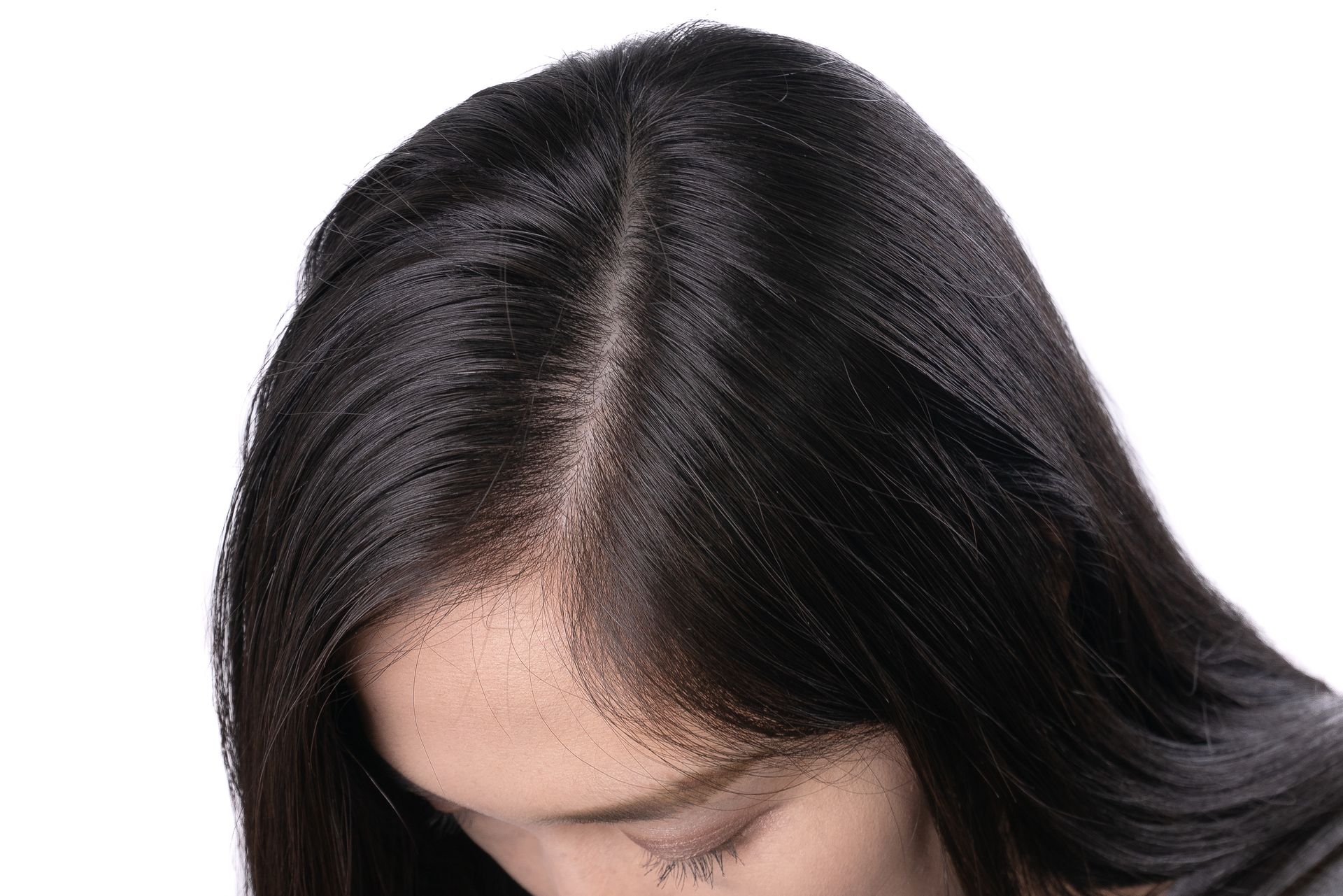 Woman with dark hair parted down the middle, looking downward.
