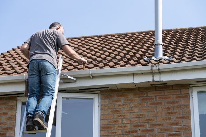 Man Cleaning Gutters — Governor John Sevier Knoxville, Tennessee — Goddard Continuous Guttering