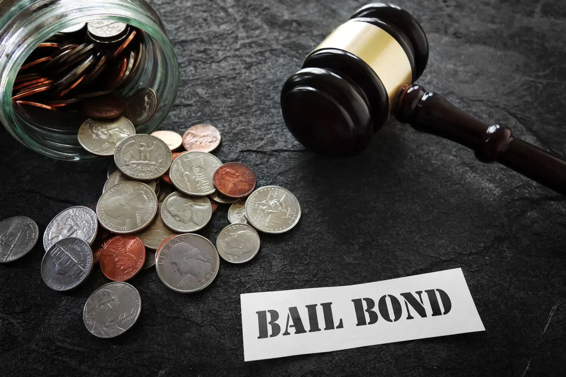 Coins beside a gavel and “BAIL BOND” label on a dark surface
