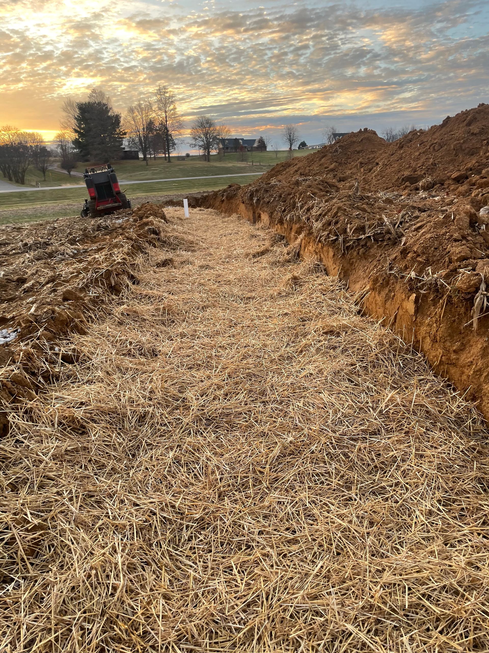A large pile of dirt is sitting in the middle of a field.