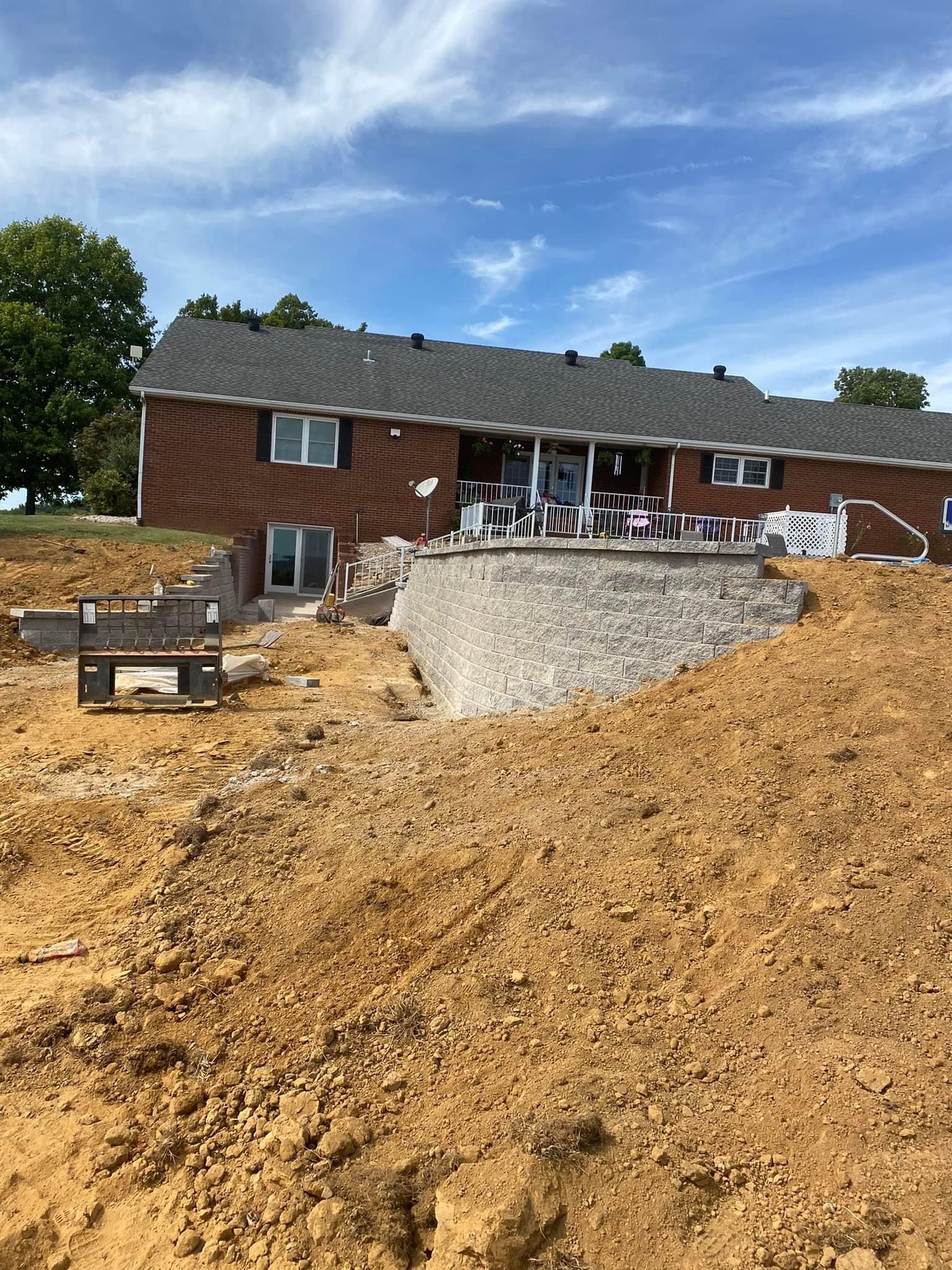 A house is being built on top of a dirt hill.