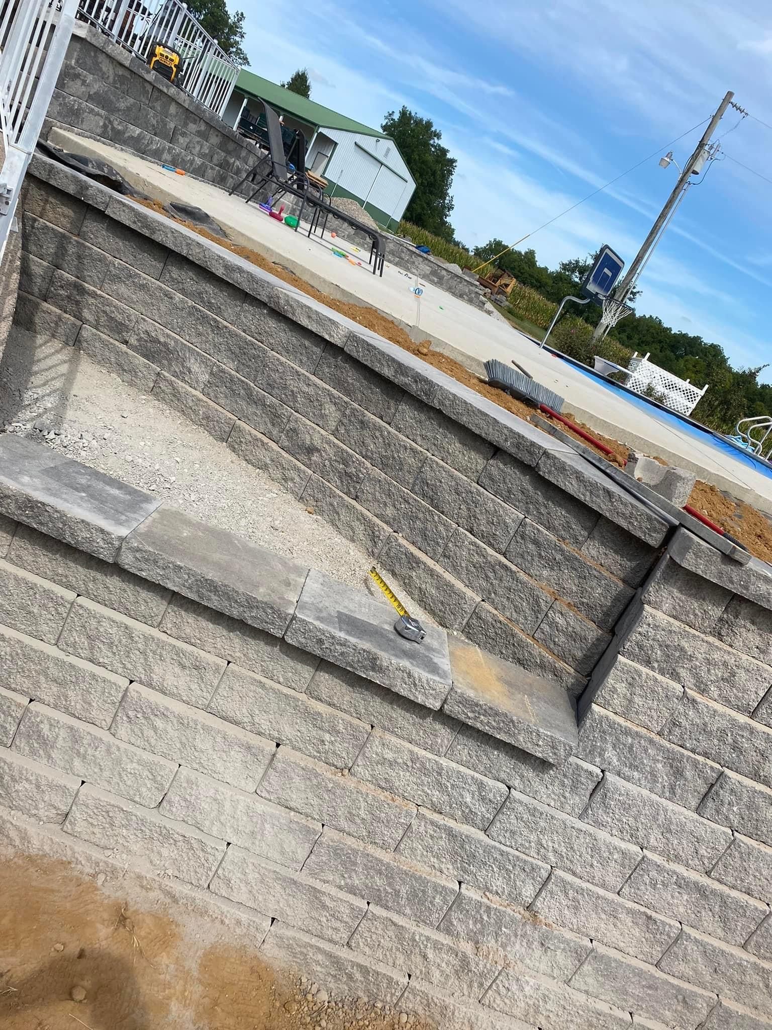 A brick wall is being built next to a road.