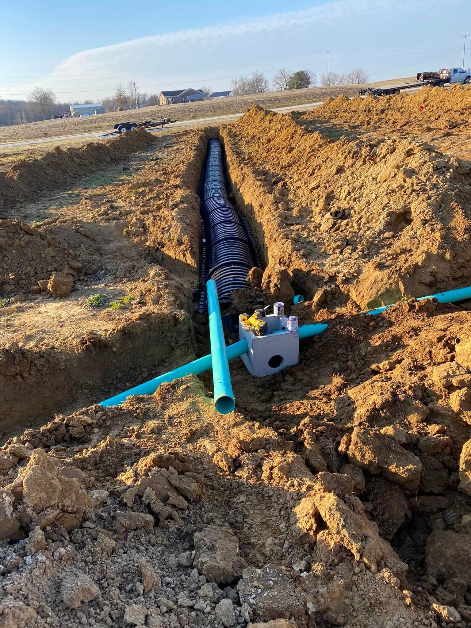 A pipe is being installed in a trench in the dirt.