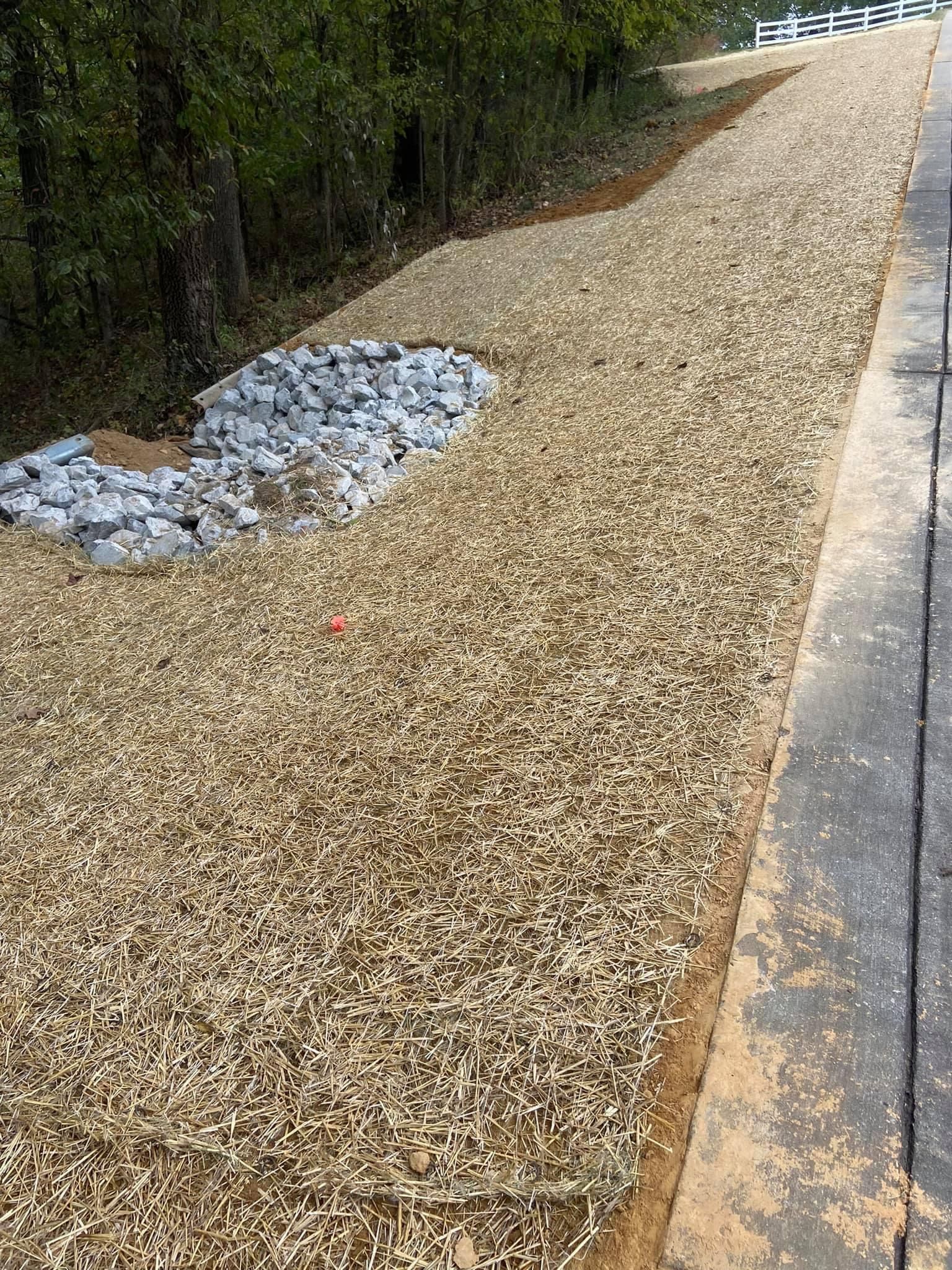 A pile of gravel is sitting next to a road.