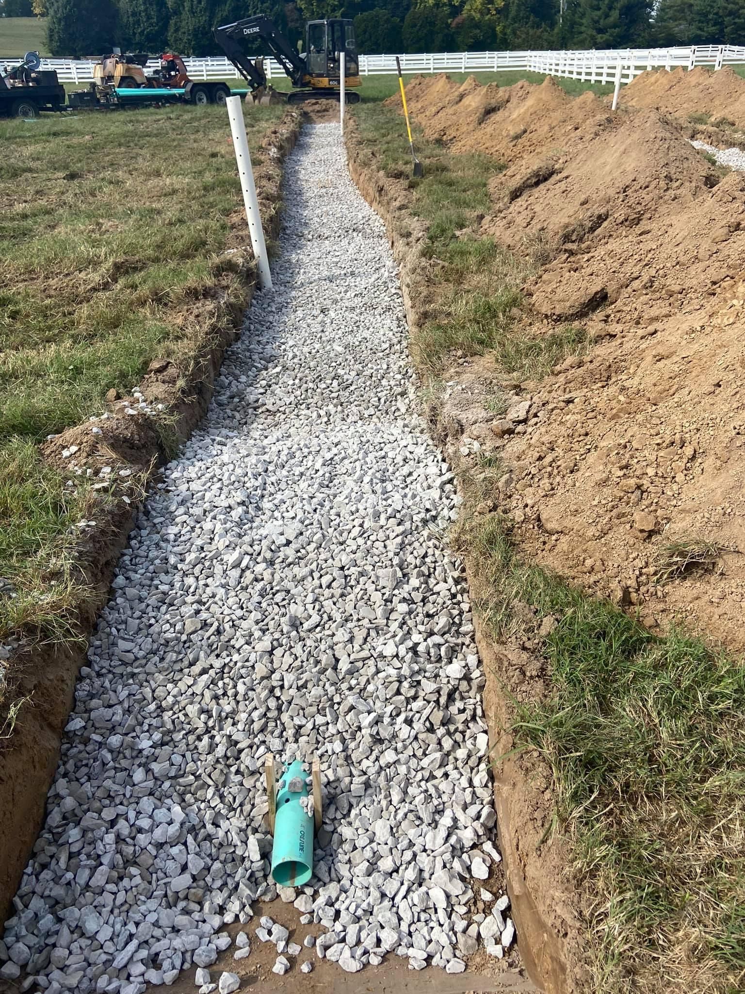 A pipe is sitting in the middle of a gravel path.