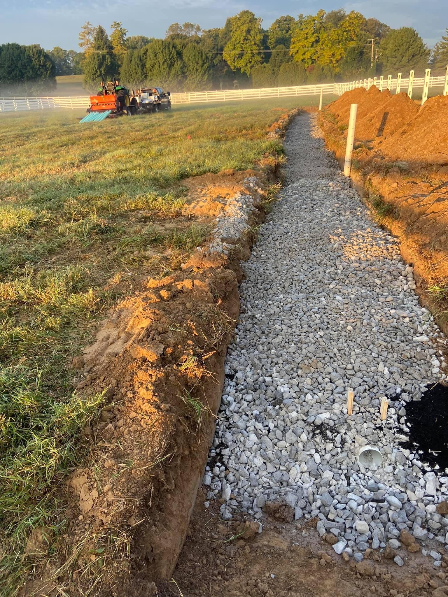 A gravel path is being built in the middle of a field.