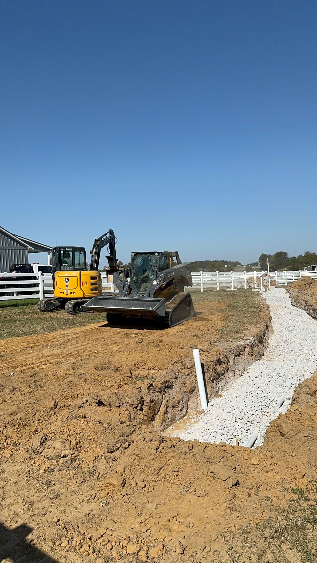 A bulldozer is digging a trench in a dirt field.