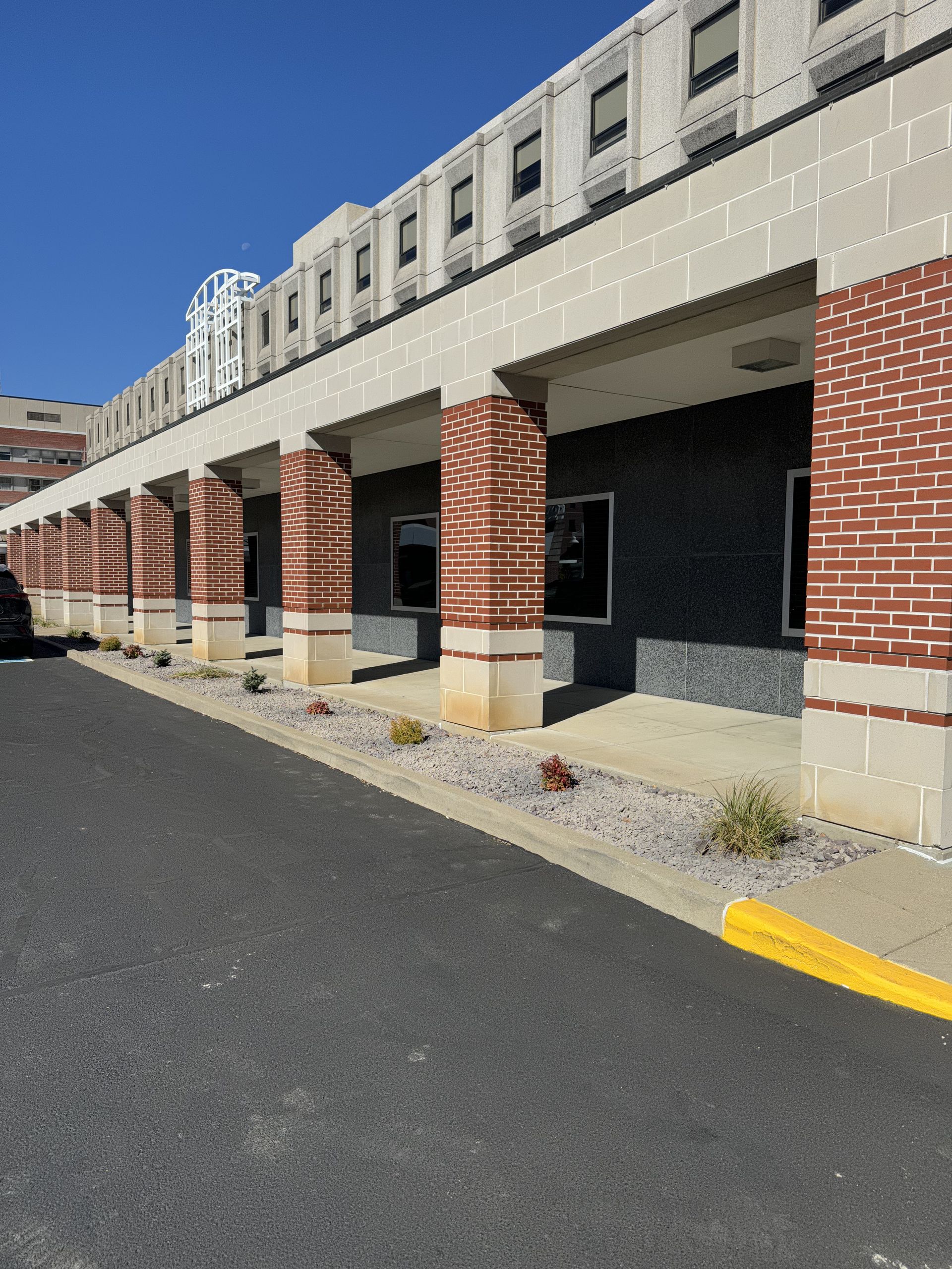 A large brick building with columns and a car parked in front of it