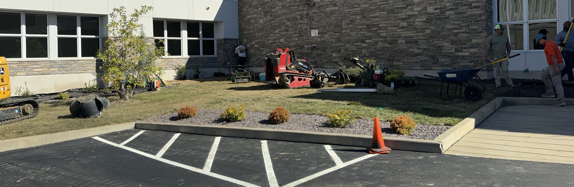 A handicapped parking spot is being painted in front of a building.
