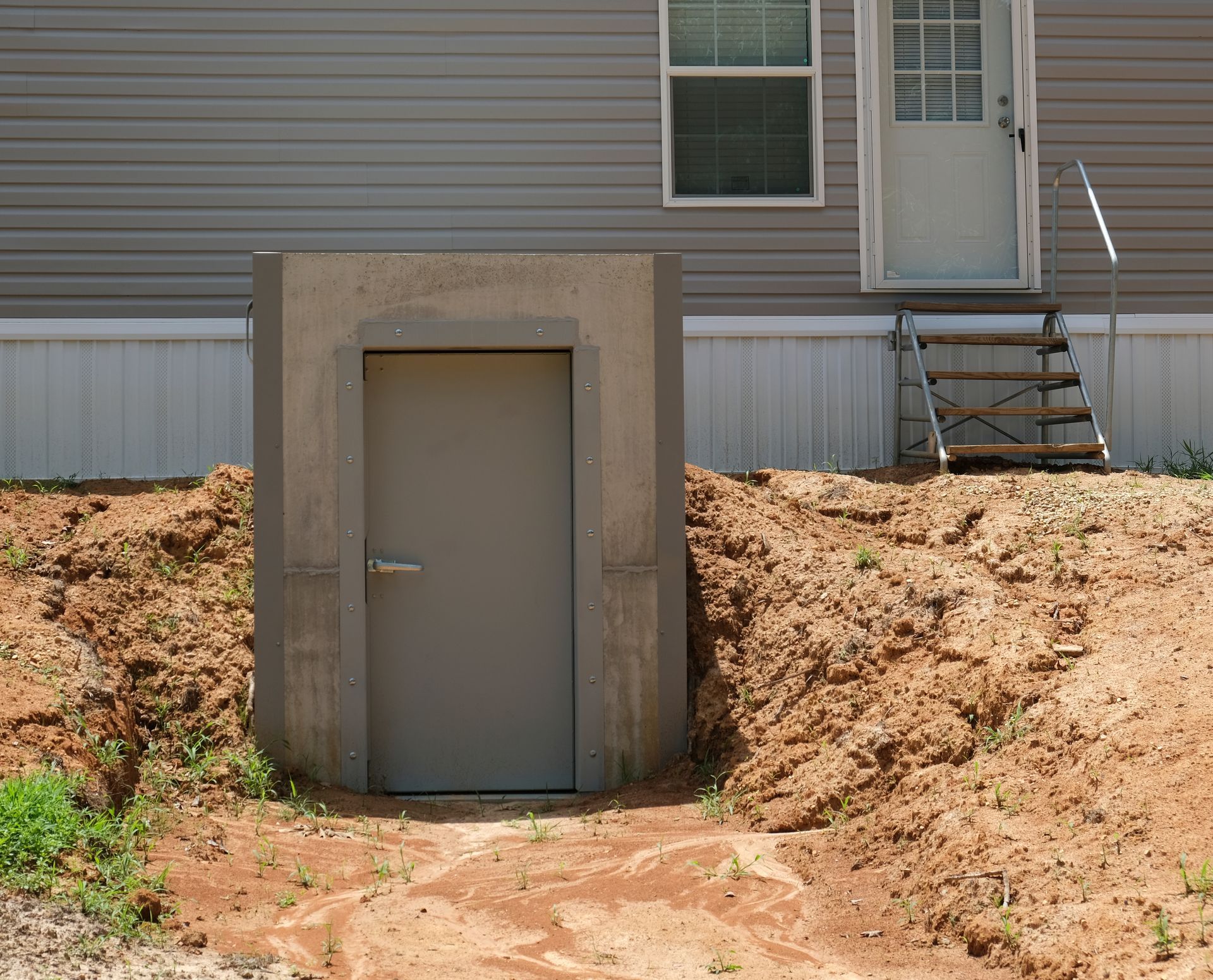 A small door in the dirt in front of a house