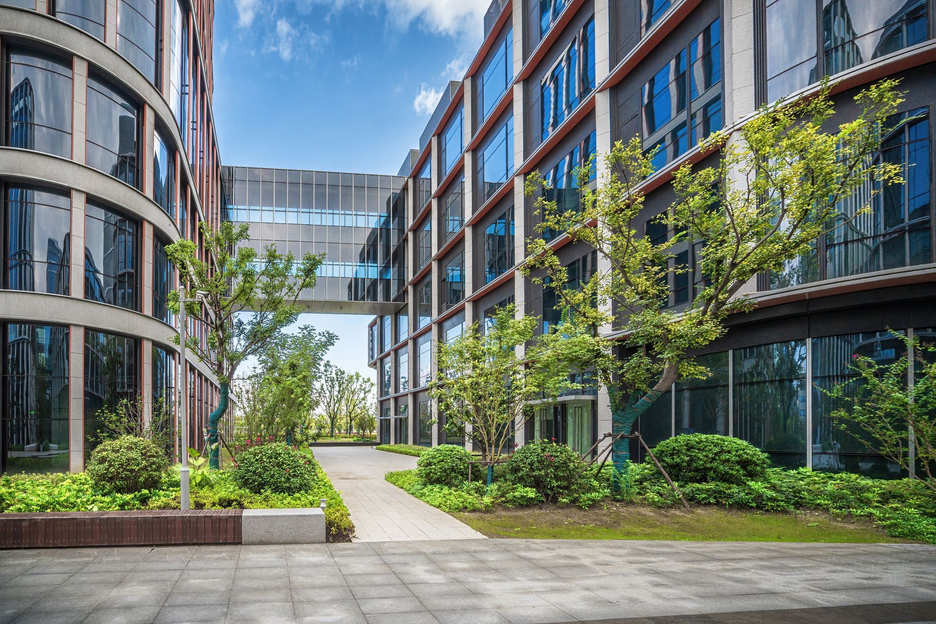 A large building with a lot of windows and trees in front of it.