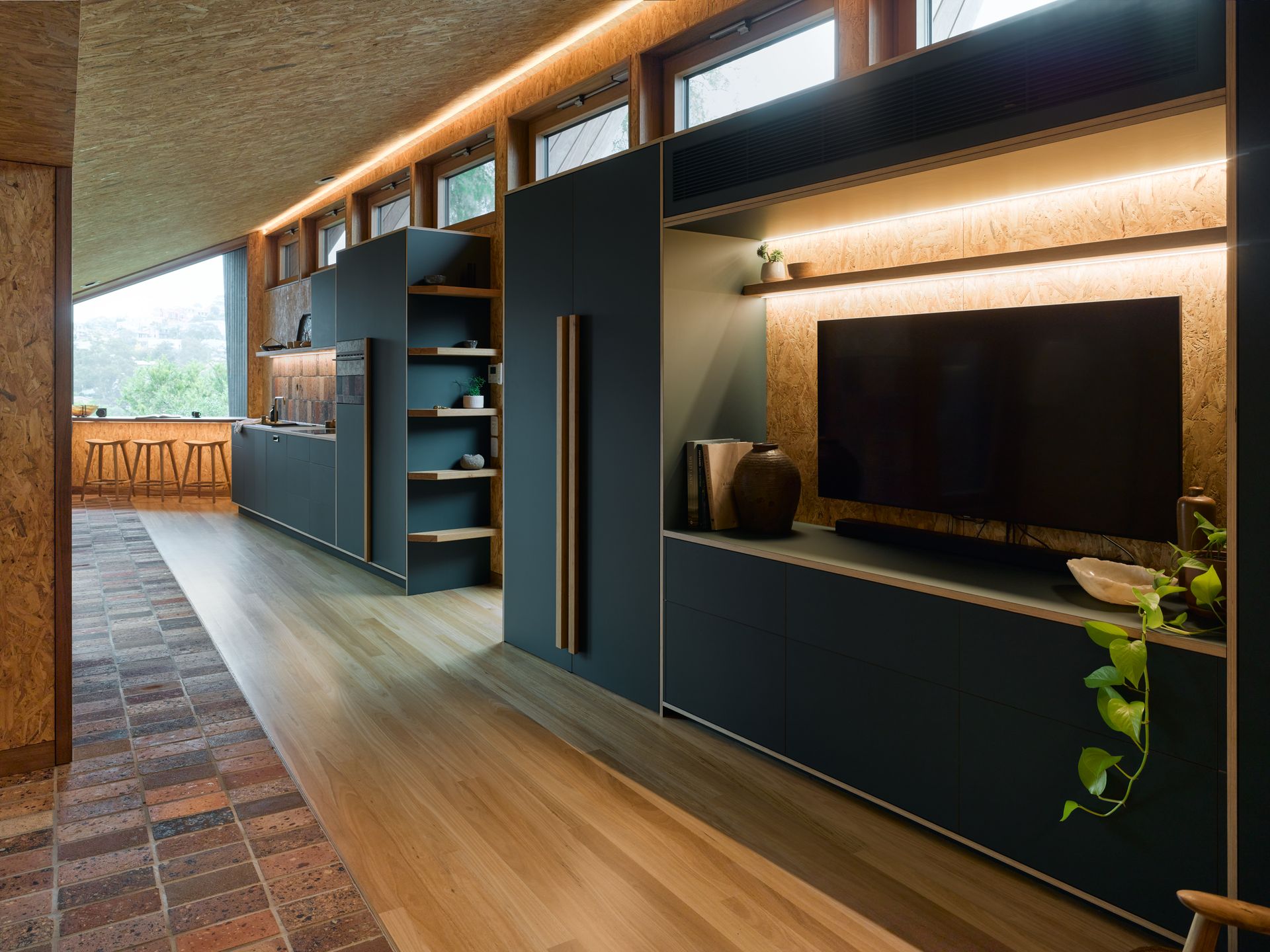 A modern living area with TV and dark cabinetry — Paiano Custom Kitchens In Corrimal, NSW