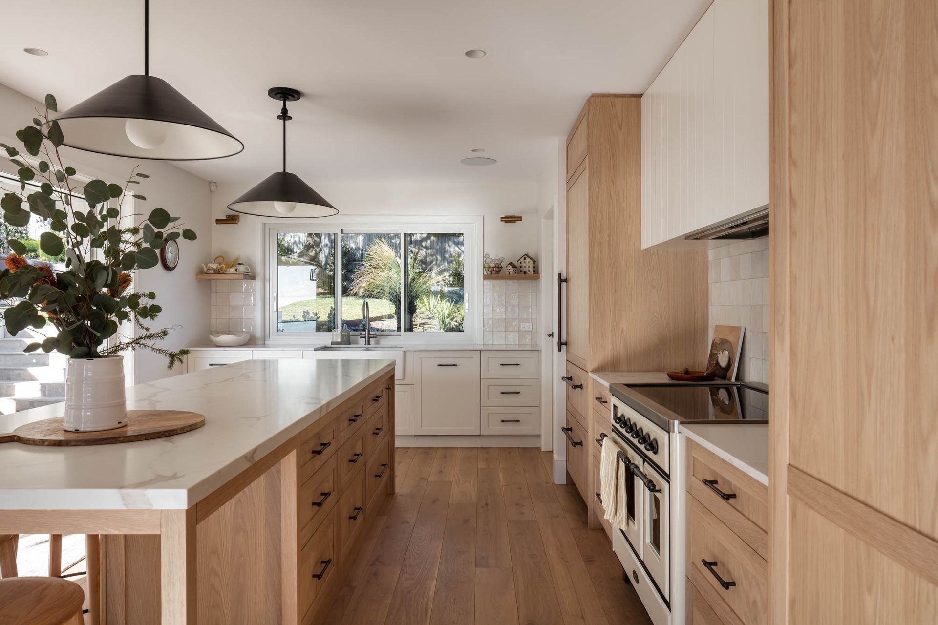 A Kitchen With Wooden Cabinets, Stainless Steel Appliances, and a Large Island — Paiano Custom Kitchens In Corrimal, NSW