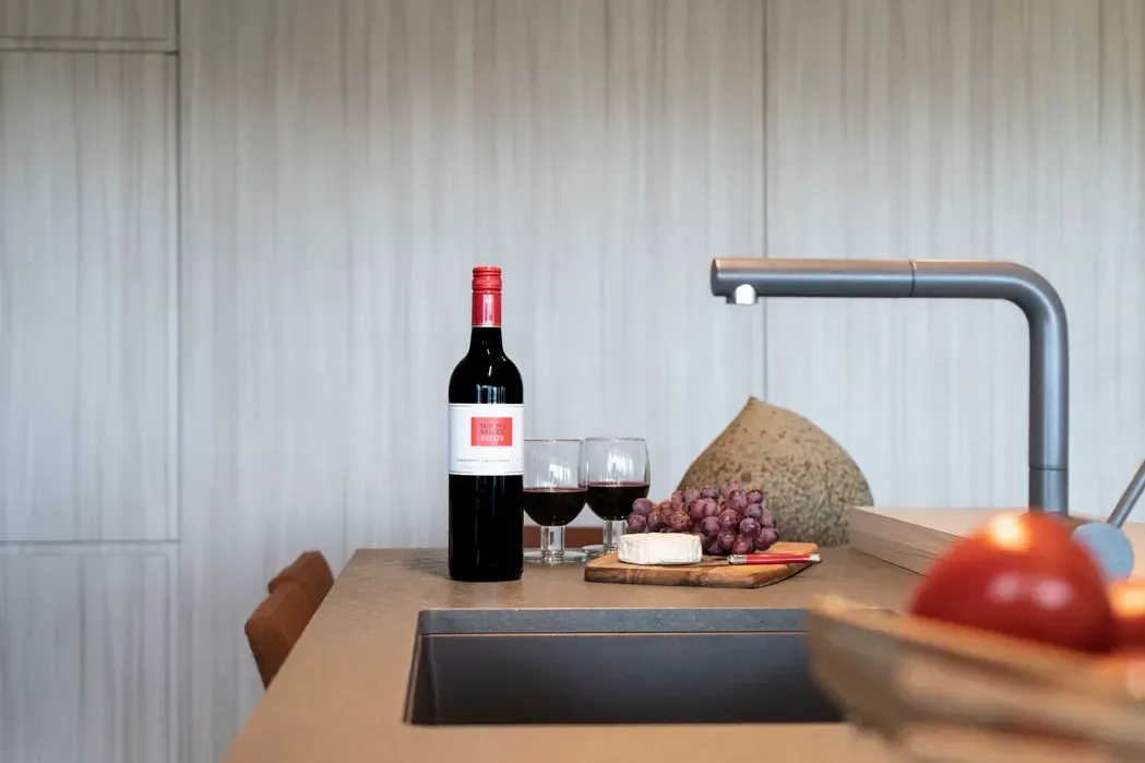 A Kitchen With a Large Island and Stools — Paiano Custom Kitchens In Corrimal, NSW