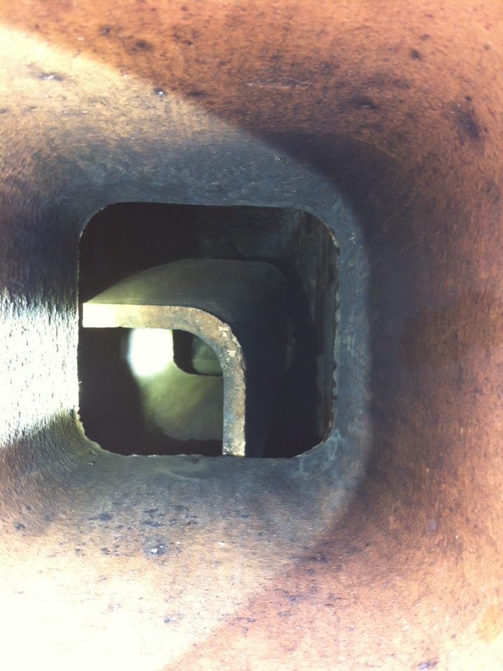 A close up of a hole in a metal pipe.