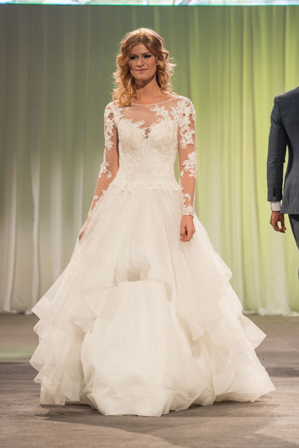 A woman in a wedding dress is walking down a runway.