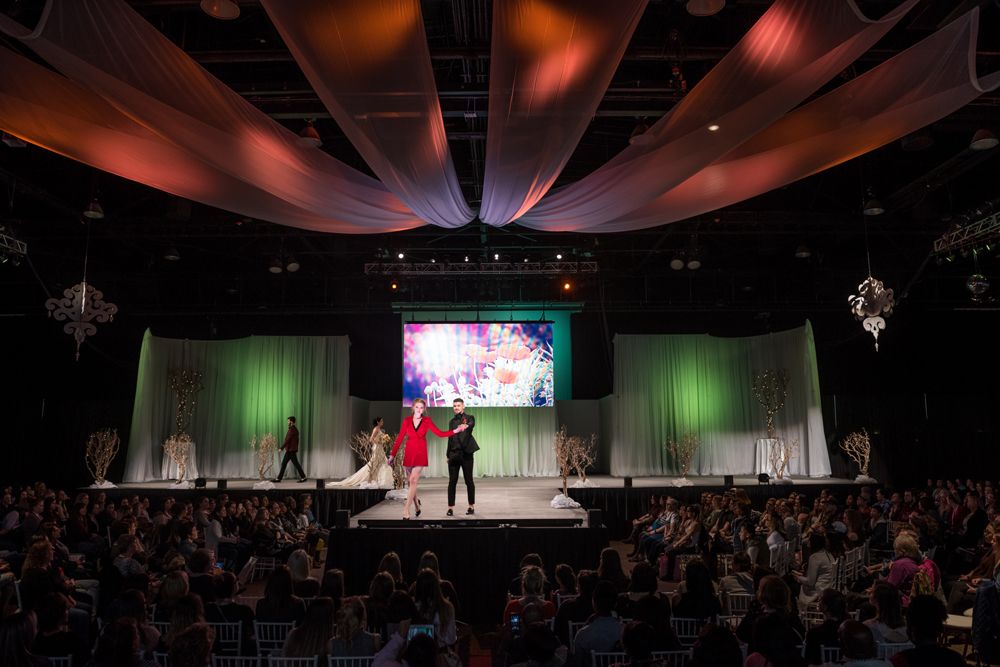 A group of people are standing on a stage in front of a crowd.