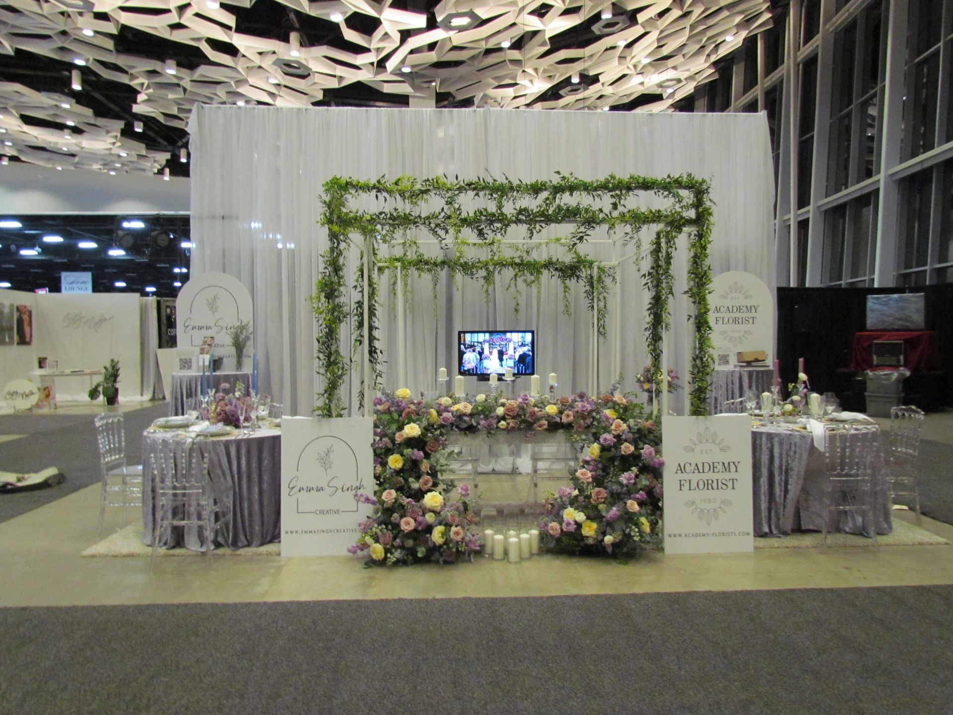 A room with flowers and a tv on the wall