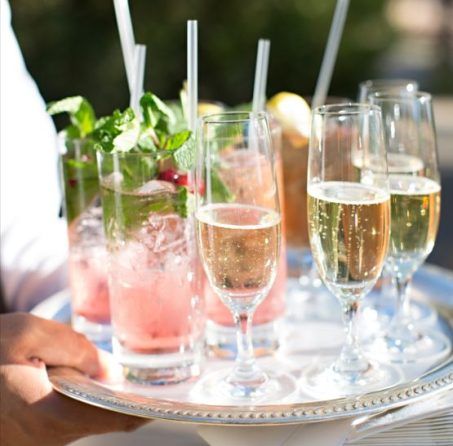A person is holding a tray of drinks with straws in them