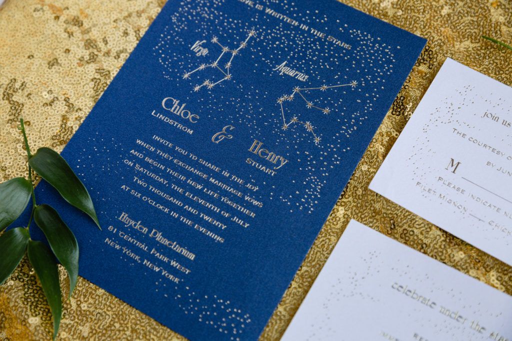 A blue wedding invitation with a constellation on it