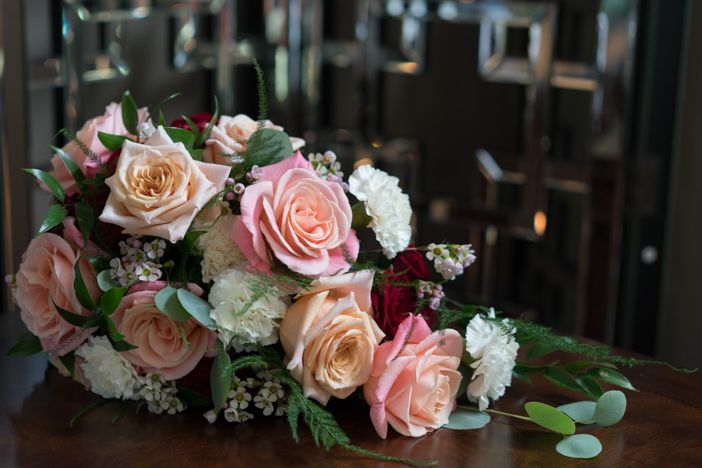 A bouquet of flowers is sitting on a wooden table.