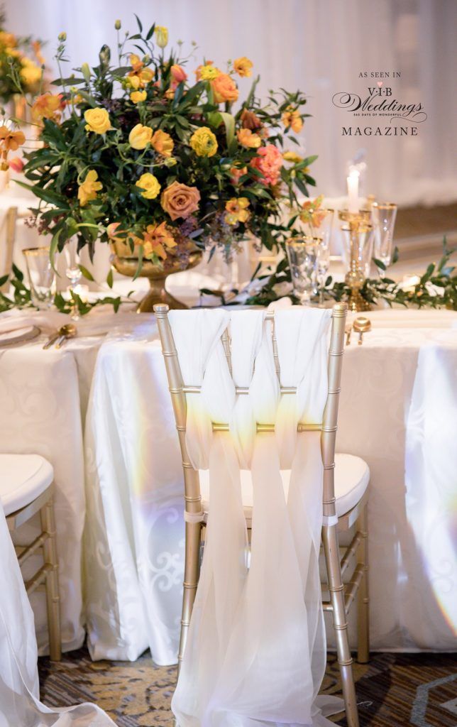 A table with a vase of flowers and candles on it.
