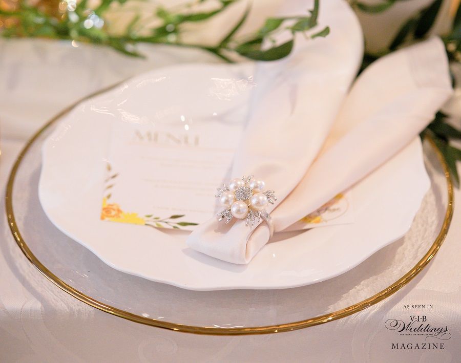 A white plate with a napkin and a ring on it.