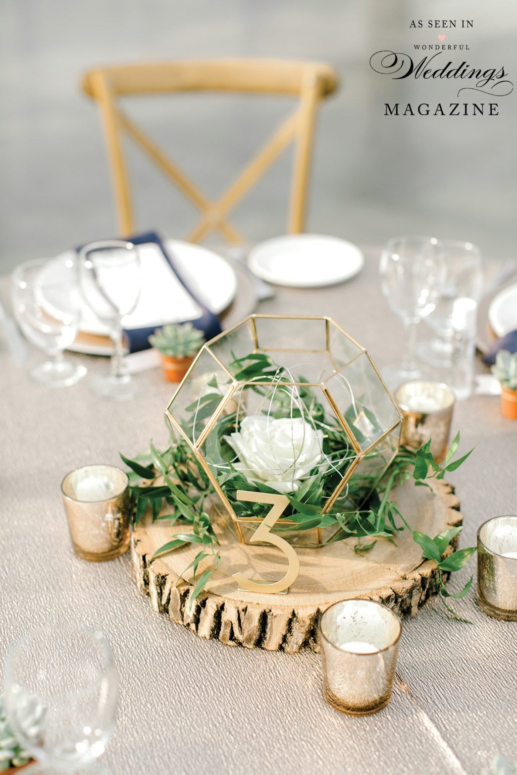 A table with plates , candles , and a geometric centerpiece on it.