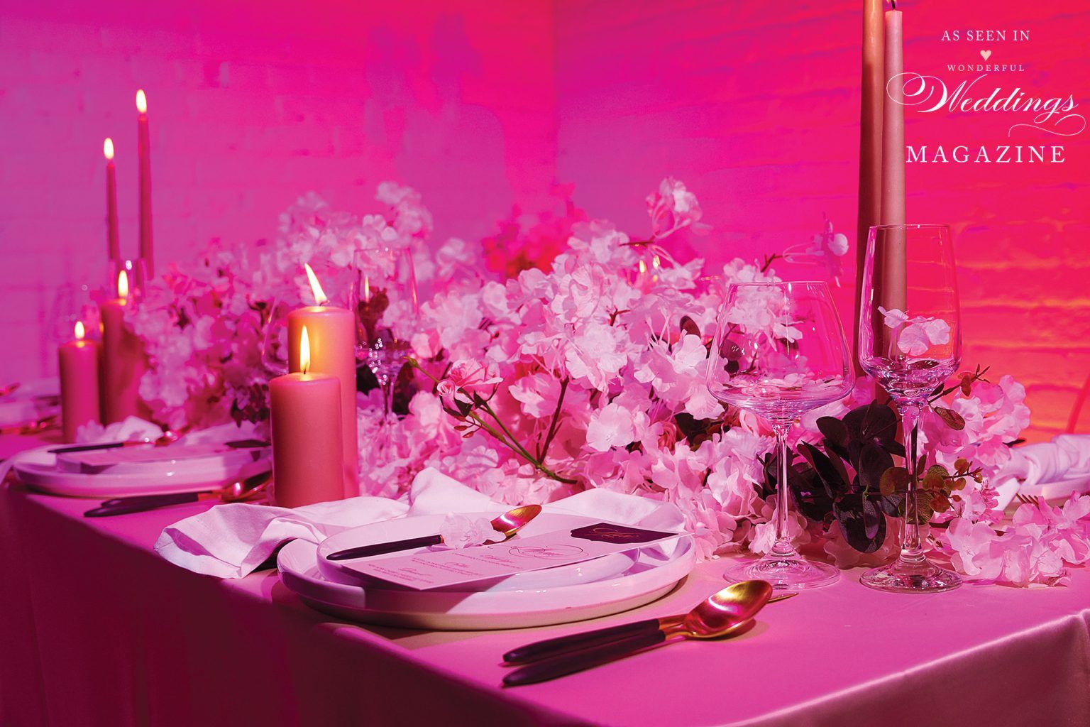 A table with plates , candles , and flowers on it.