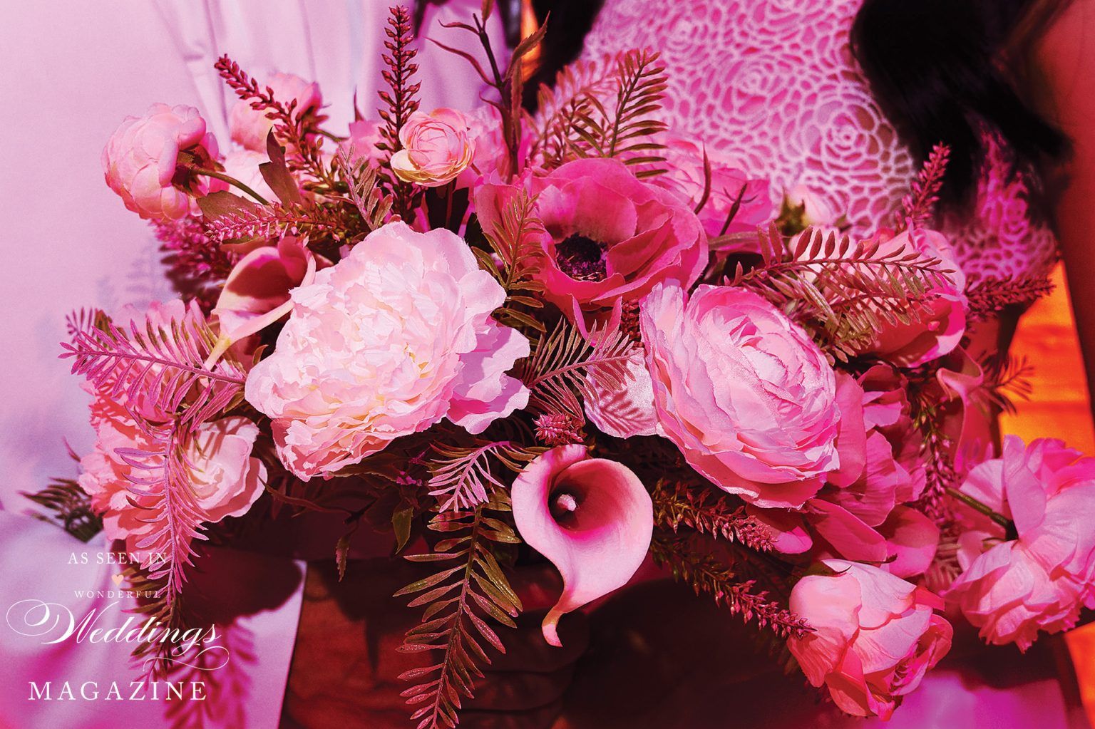 A woman is holding a bouquet of pink flowers.