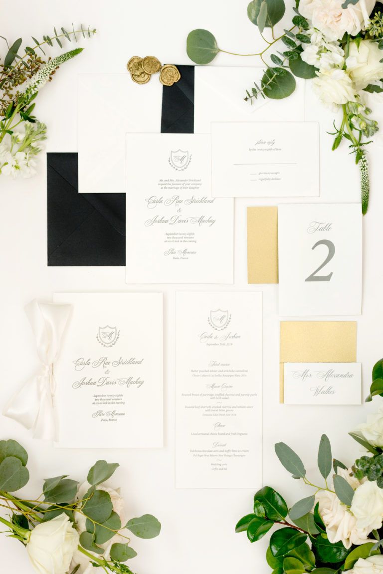 A bunch of wedding invitations and flowers on a table.