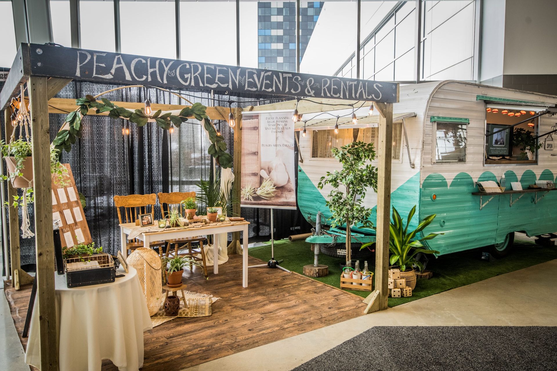A peachy green event rental booth with a table and chairs.