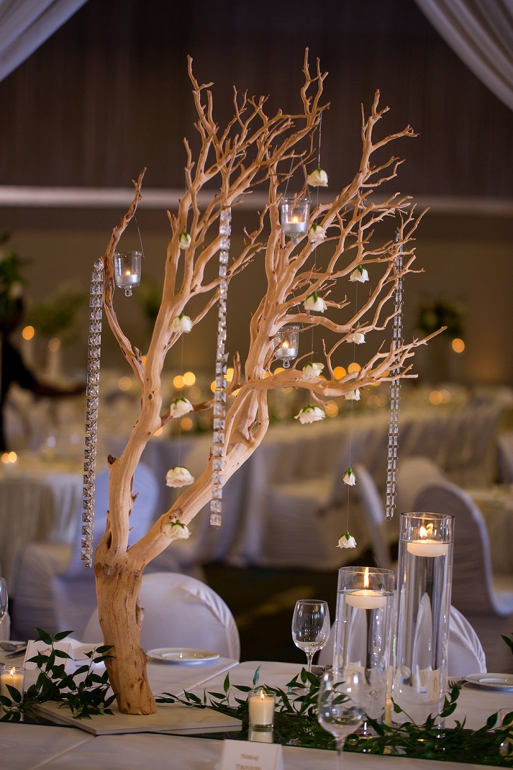 A tree with candles hanging from it is sitting on top of a table.