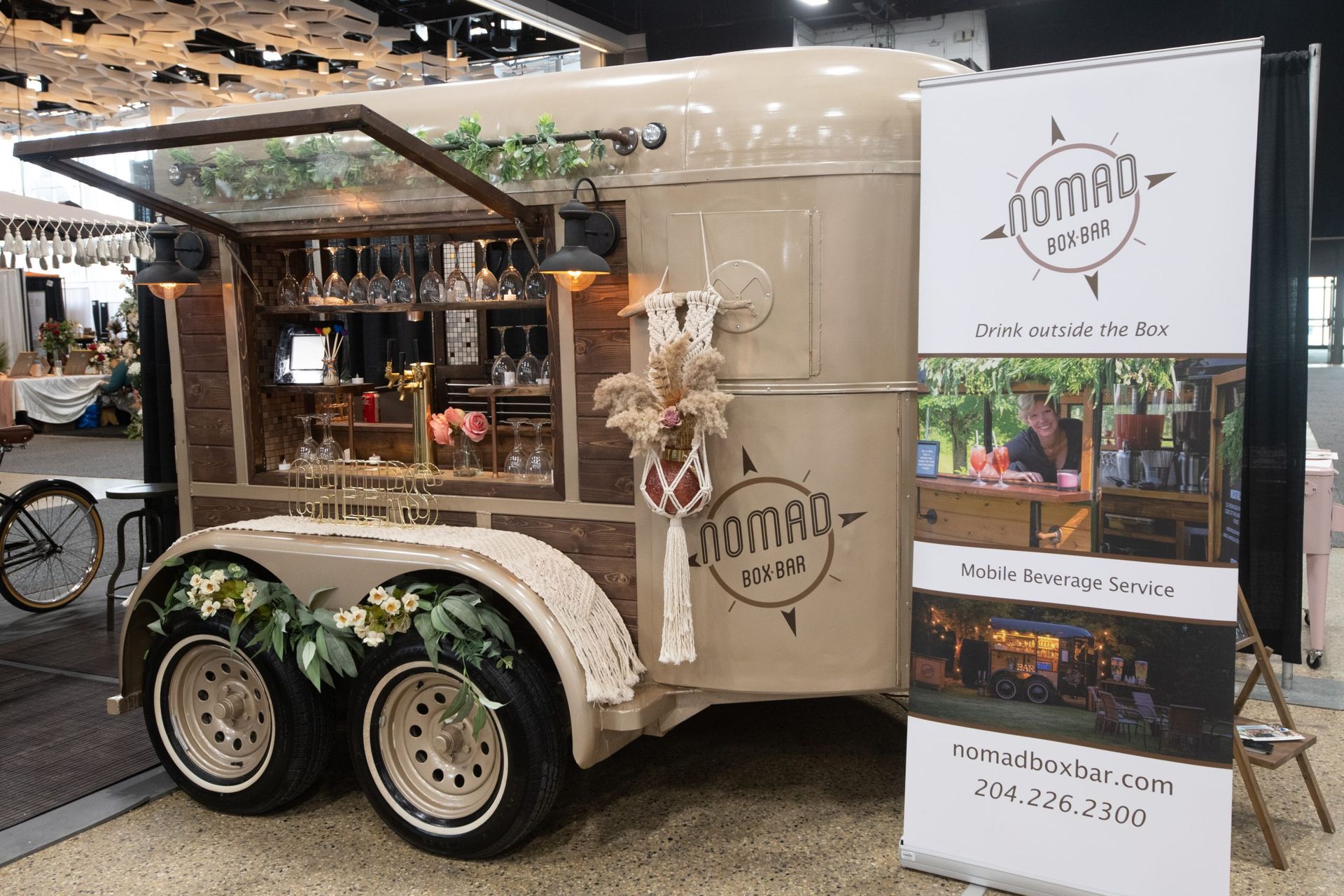A trailer with a bar on it is parked next to a sign.