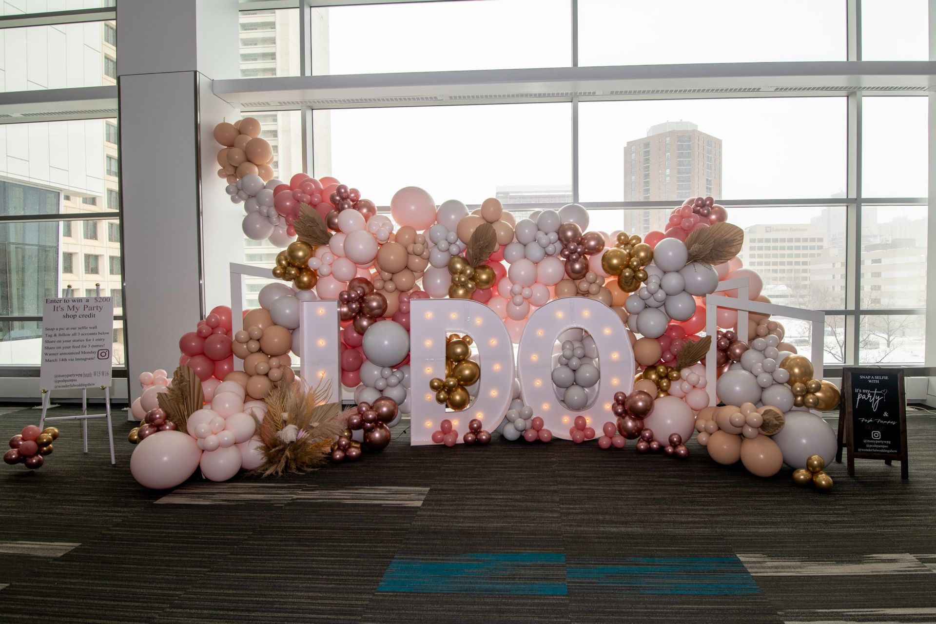 A wall filled with balloons and a sign that says `` it 's a boy ''.
