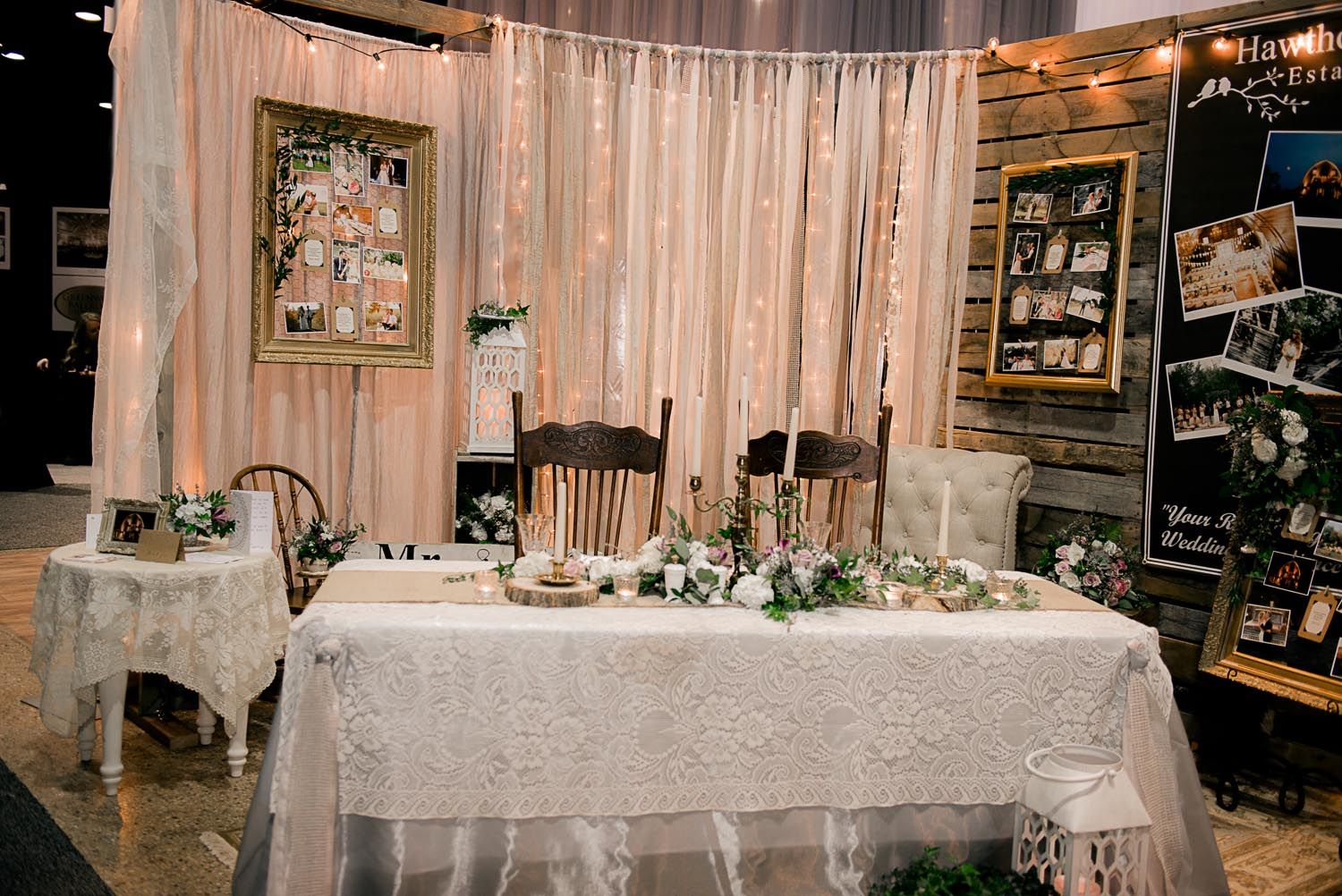 A table with a lace tablecloth is sitting in front of a wooden wall.