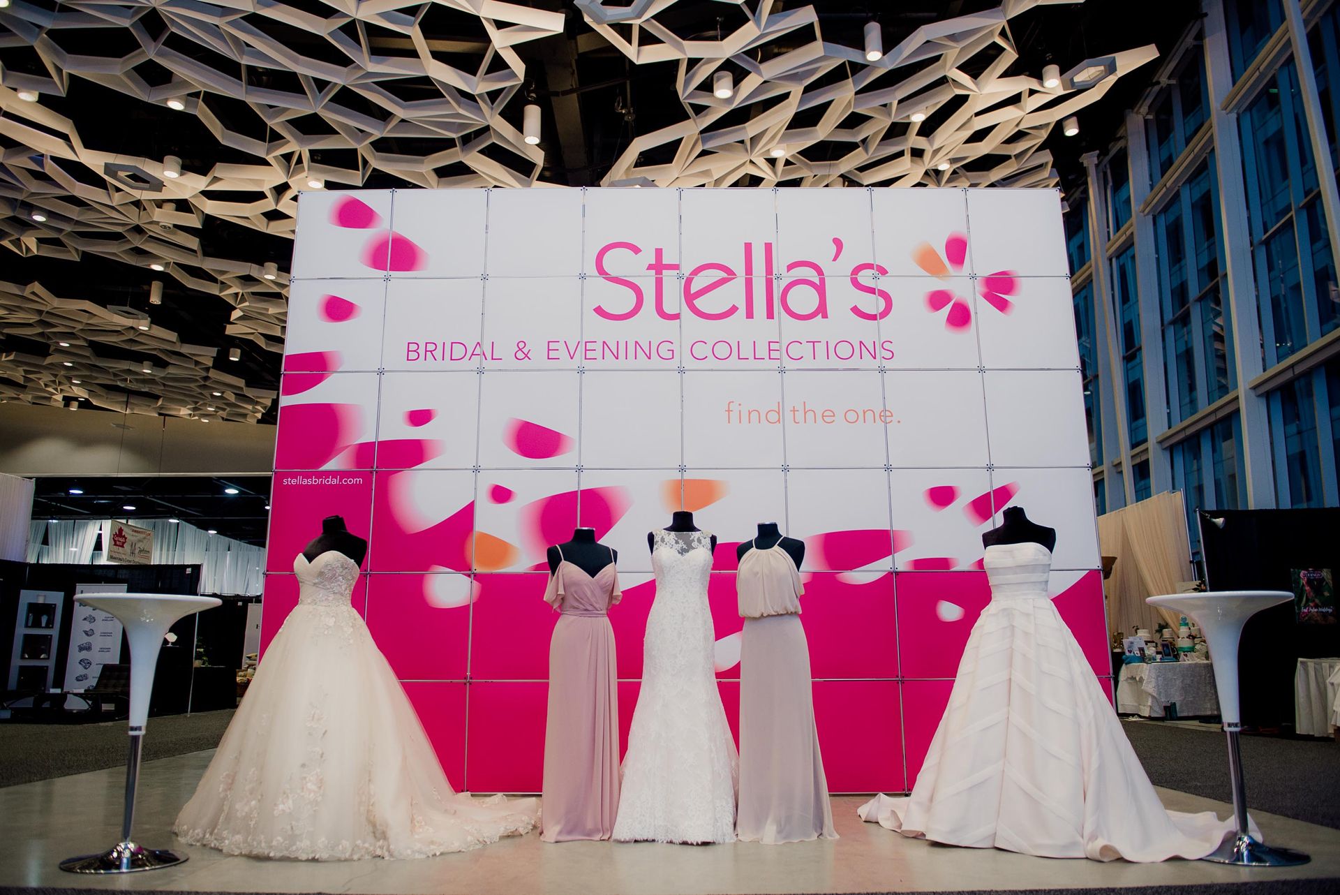 A display of wedding dresses in front of a sign that says stella 's