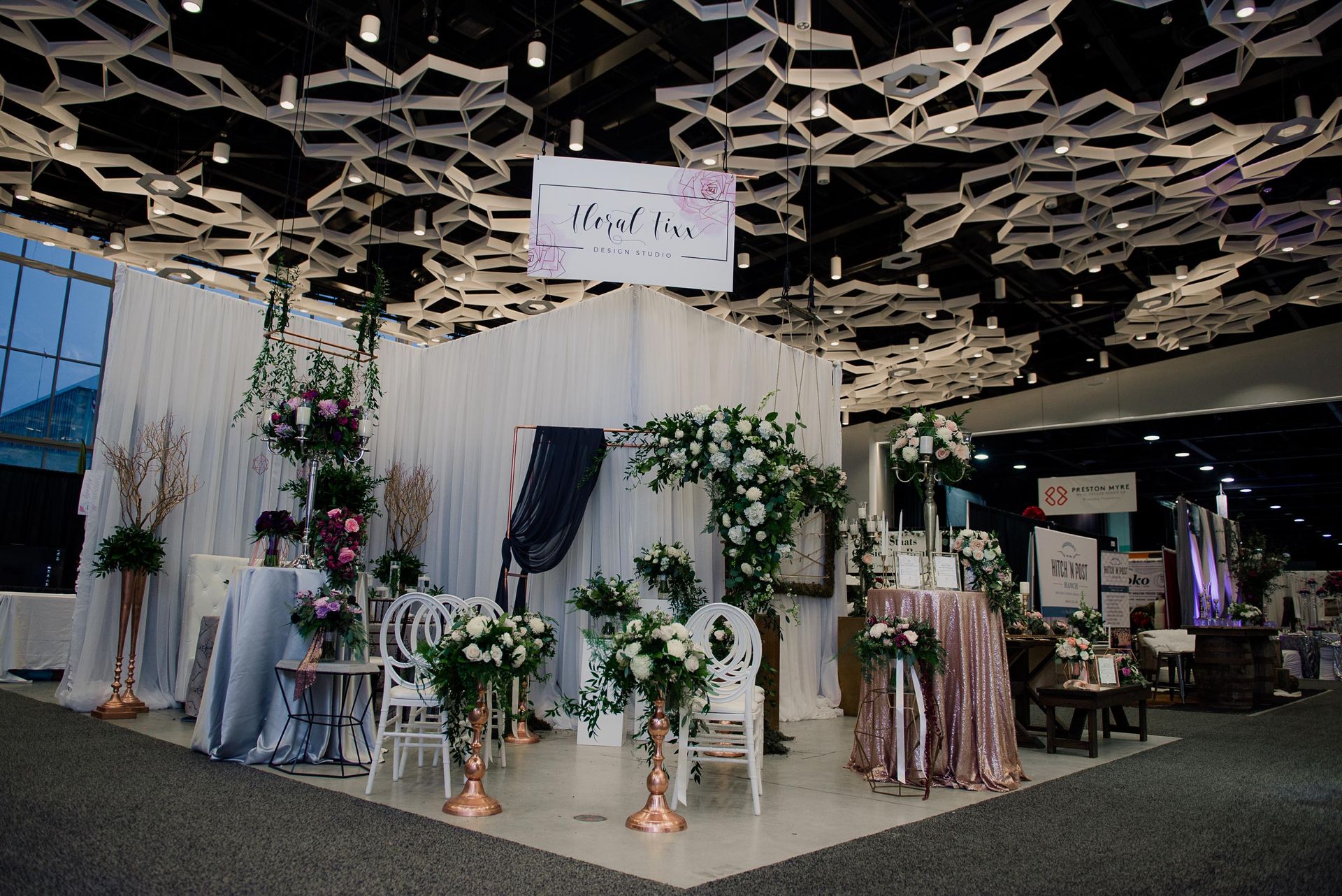 A room filled with lots of flowers and tables and chairs.
