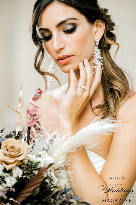A woman in a wedding dress is holding a bouquet of flowers.