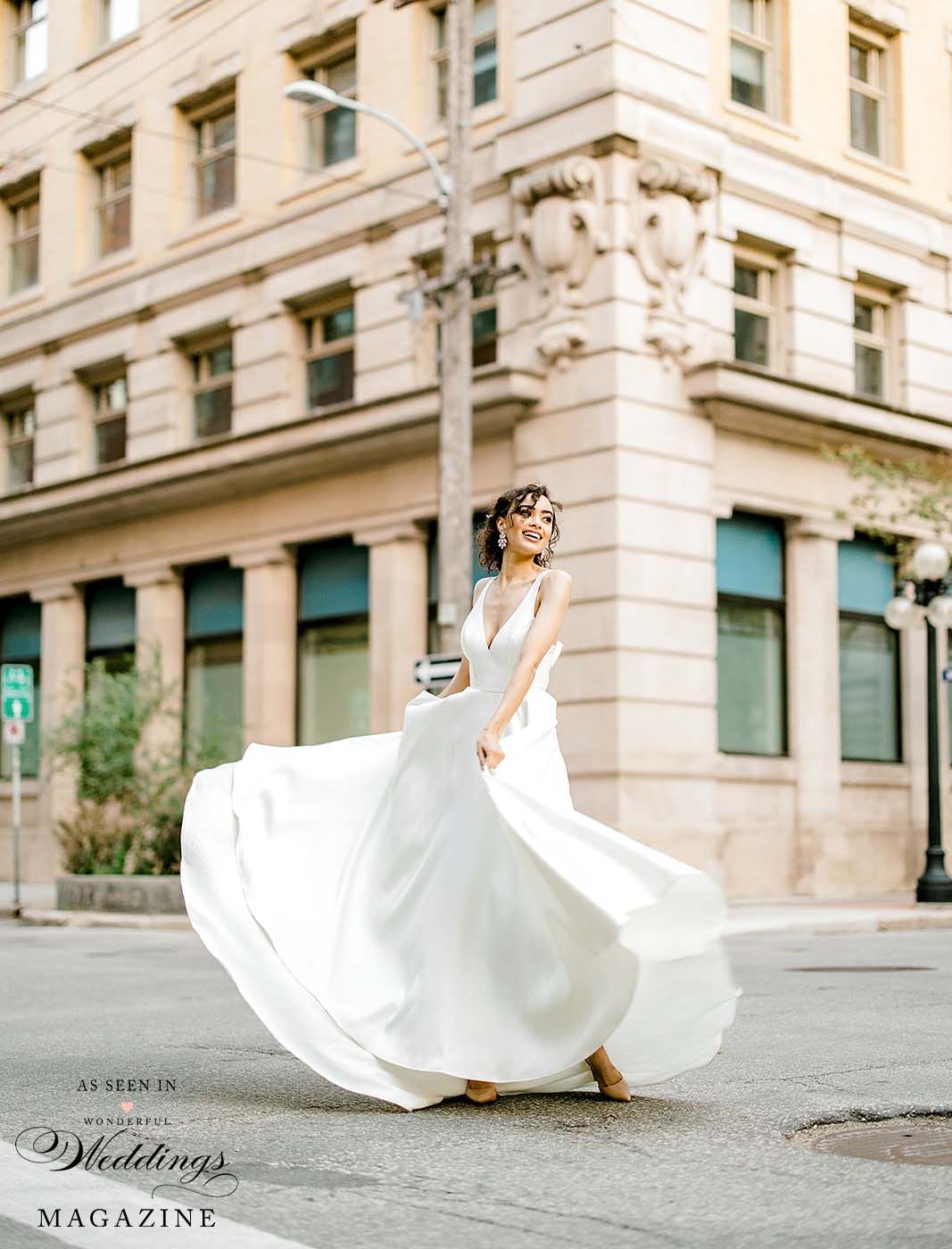 A woman in a wedding dress is walking down the street.