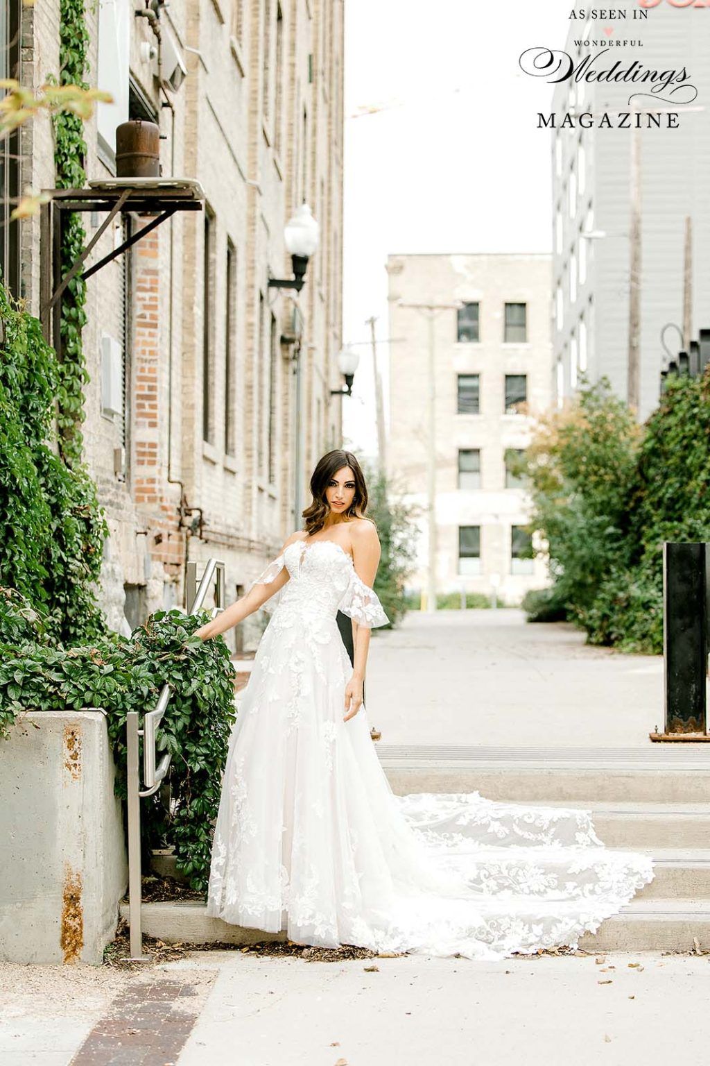 A woman in a wedding dress is standing in front of a building.