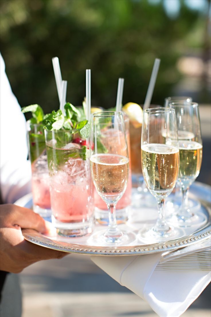 A person is holding a tray of drinks with straws in them