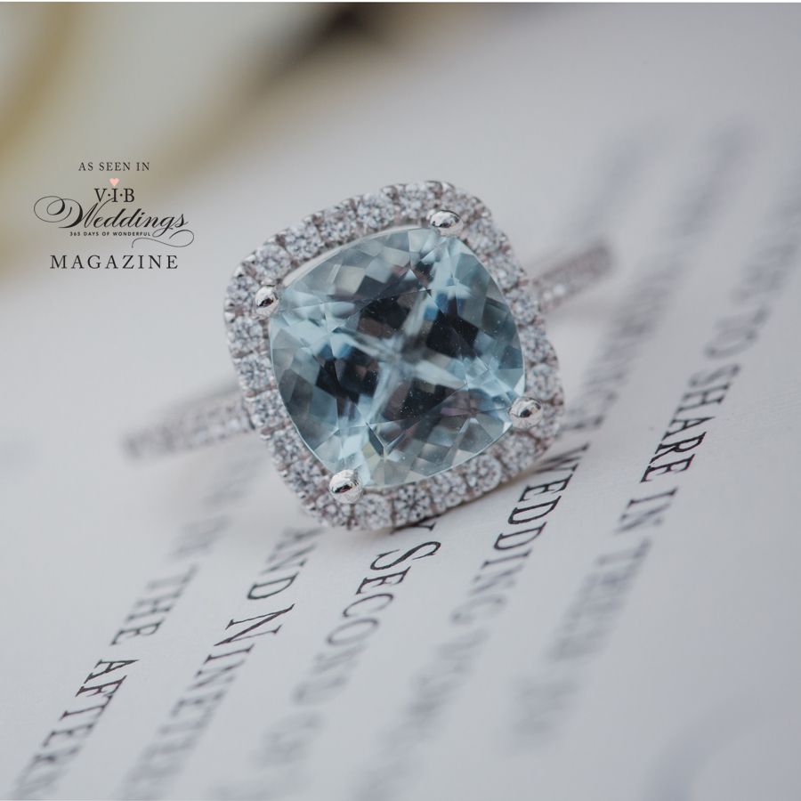 A wedding ring is on top of a wedding invitation