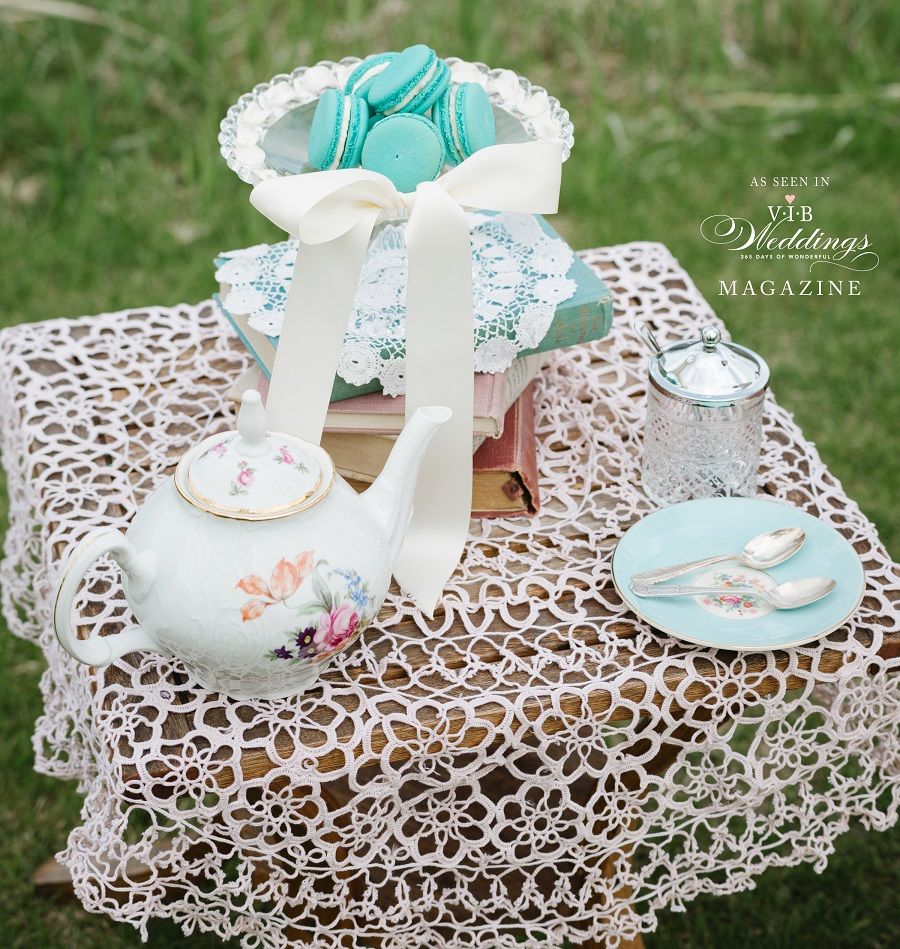 A table with a teapot and macarons on it