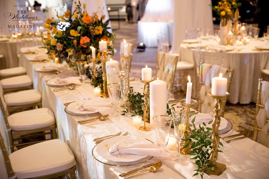 A long table with plates , candles , and flowers on it.