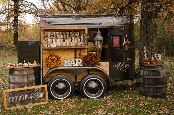 A trailer with a bar on it is parked in a field.